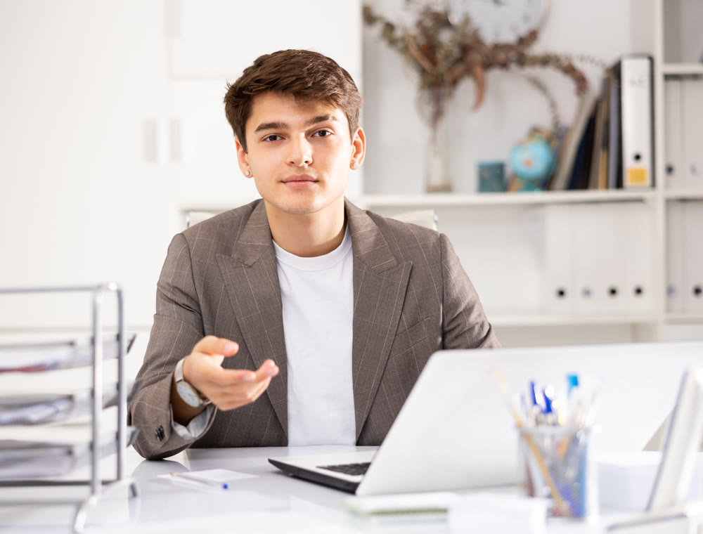 Businessman offerring hand for greeting in office interior