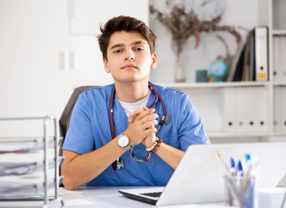 Focused doctor therapist works at a hospital computer, studying outpatient cards patients in resident office