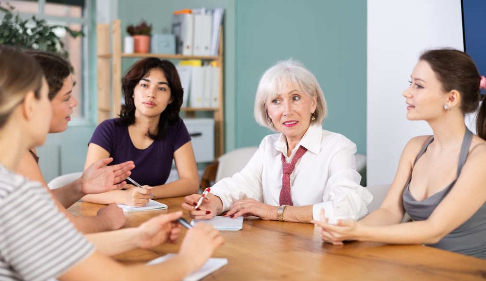 Group of women solving problems sitting around the table