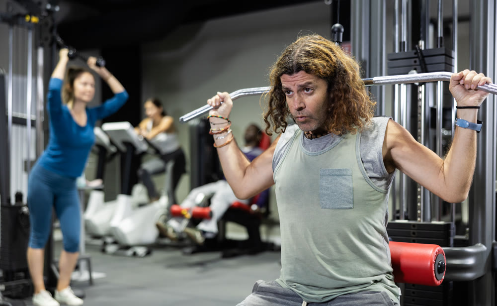 Caucasian man is engaged in a simulator for development of back muscles