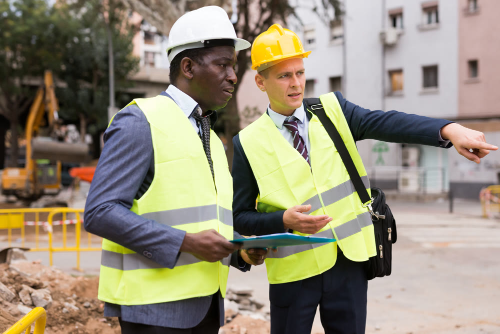 Young worker is discussing a project with a colleague, showing him something