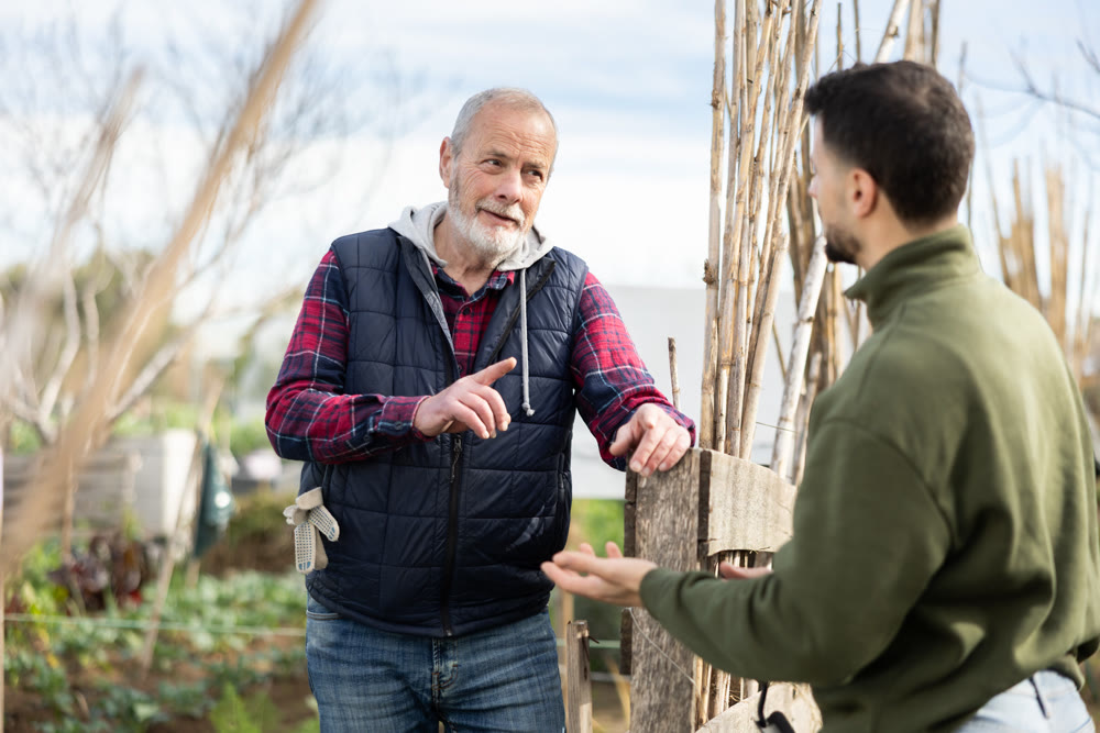Elderly and young man talking in garden