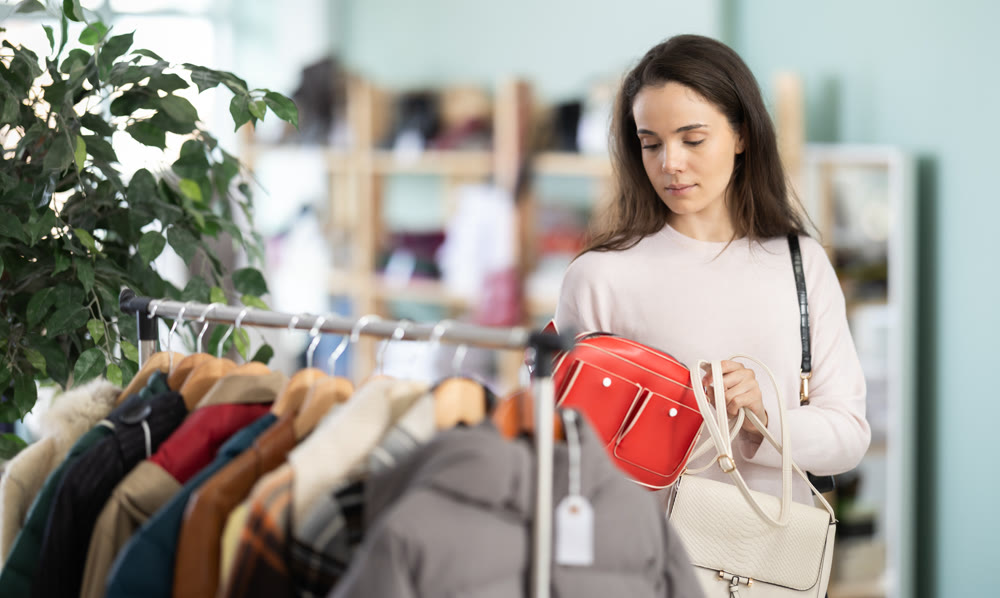 Woman carefully choosing a stylish bag in the store