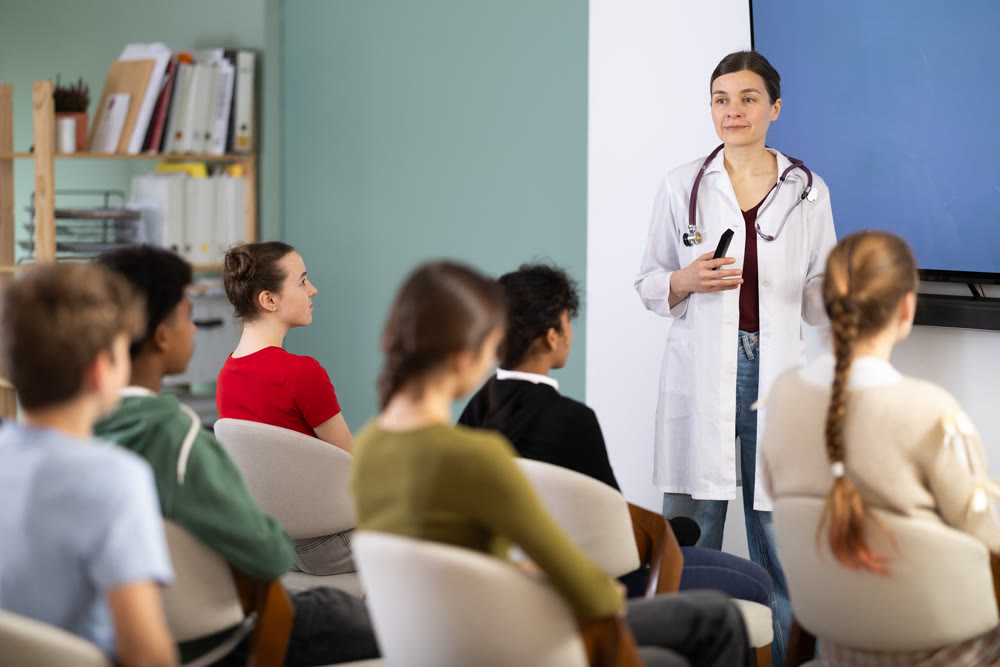 During talk in at class, teen pupil listen to doctor lecturer