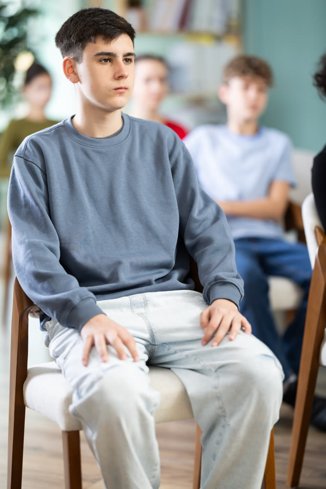 Caucasian teen boy attendee group class and listen to lecturer.