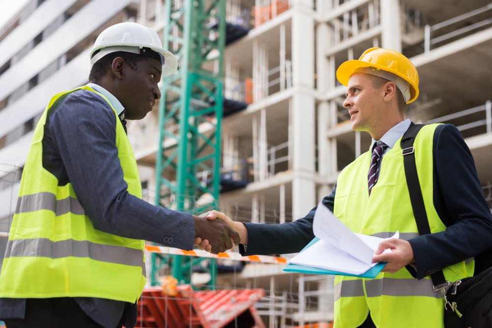 Two successful civil engineers exchange a friendly handshake
