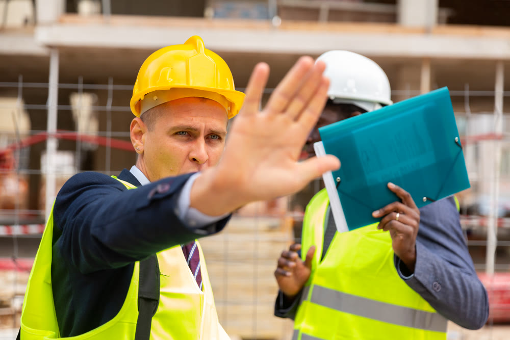 Foreman prohibits photographing on the construction site, closing camera lens
