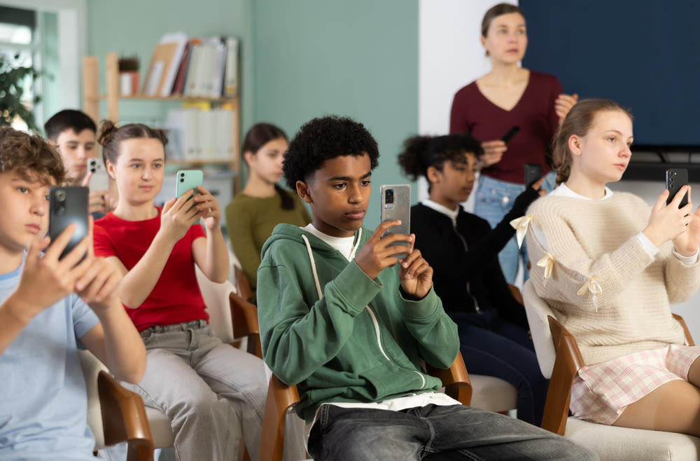 Afro American boy scans the qr code of a school lecture