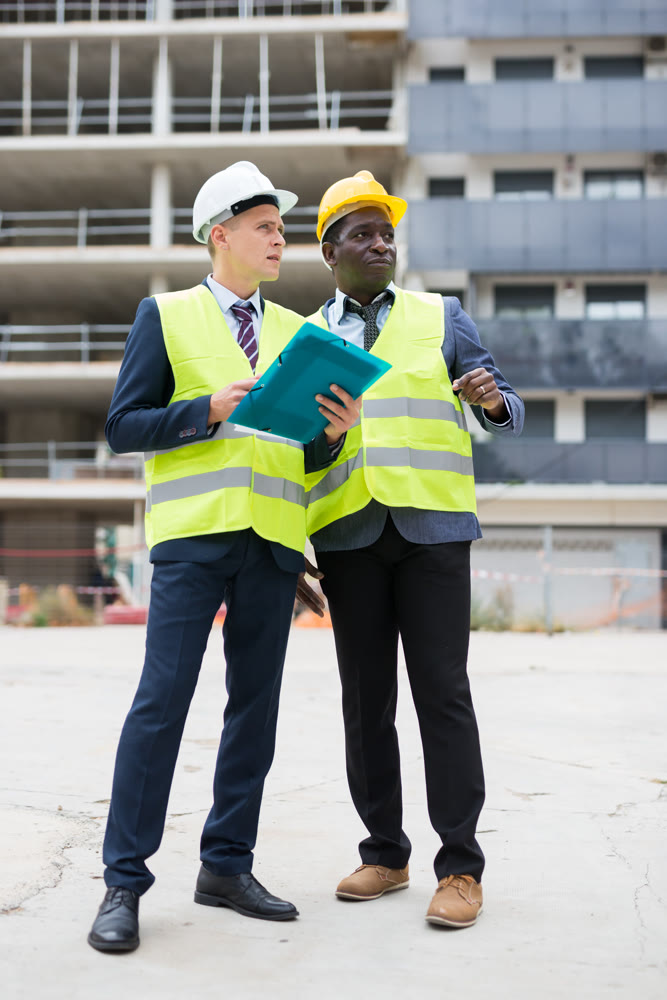 Engineer and architect discusses construction plan at construction site outdoor