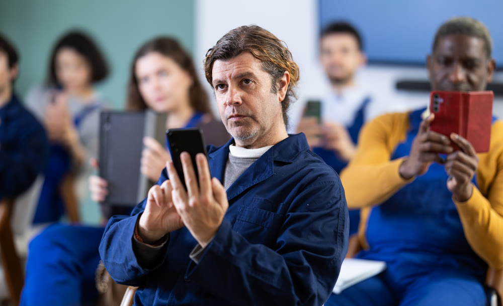 Adult man worker takes photo or scans QR code with mobile phone