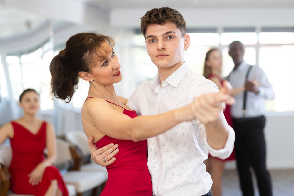 Young man and woman dancing waltz in couple during lesson at studio