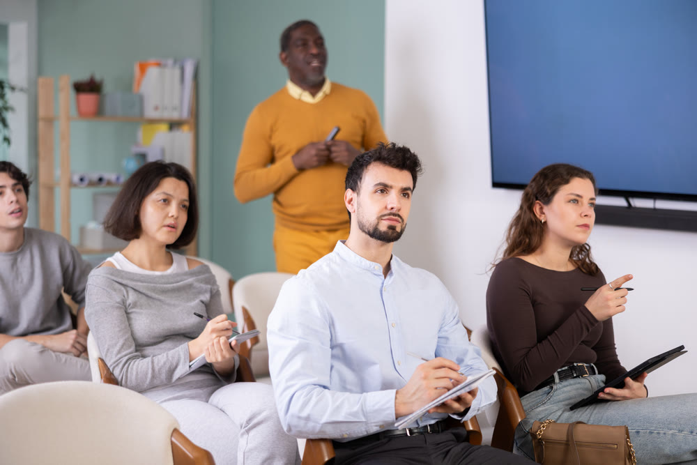 Multinational group listens and takes notes lectures in lecture hall