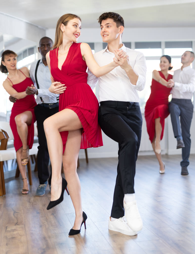 Guy practicing vigorous jive with female partner at dance class