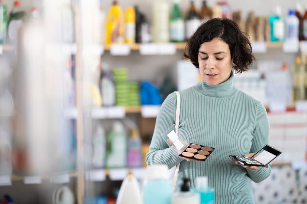 Middle-aged woman choosing cosmetics at supermarket