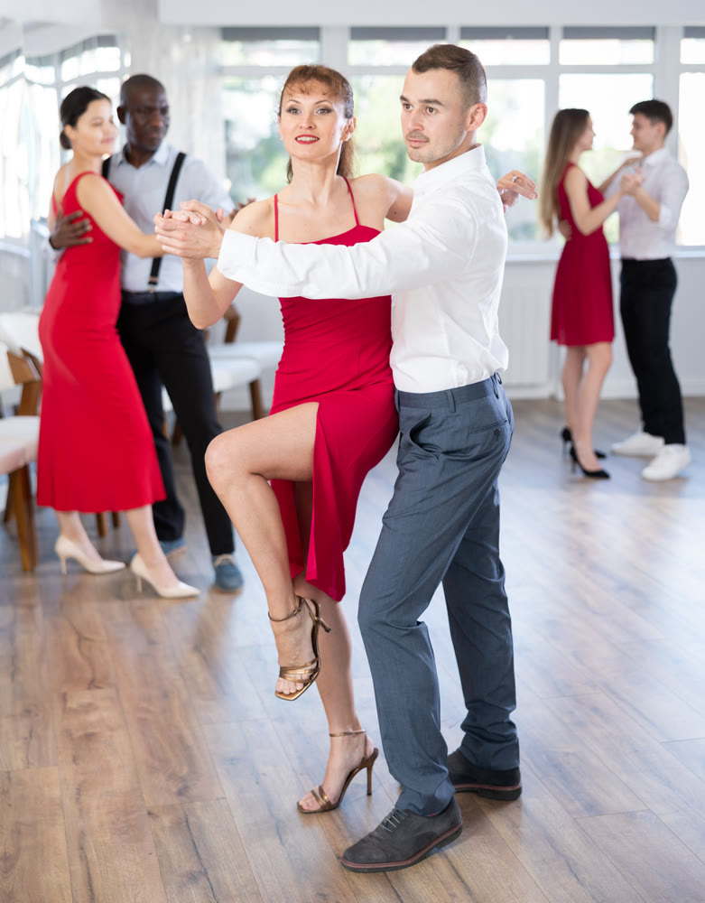 Graceful duet engrossed in passionate tango during group dance class