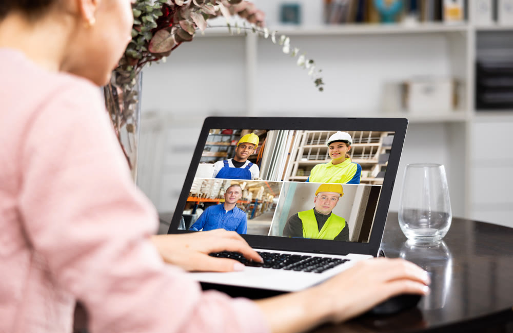 Woman with laptop having video call with co-workers at home