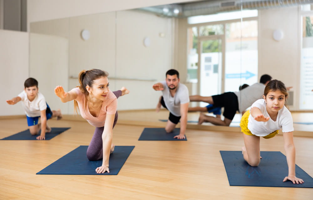 Tween girl performing Balancing Table pose during family yoga class