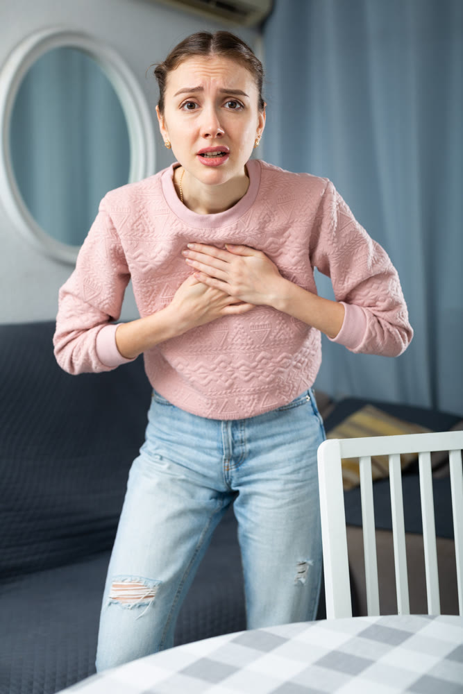 Young woman suffering from chest pain