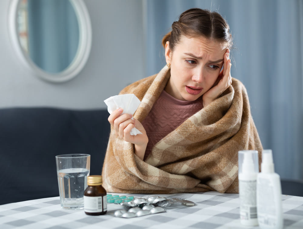 Ill woman suffering from headache at home