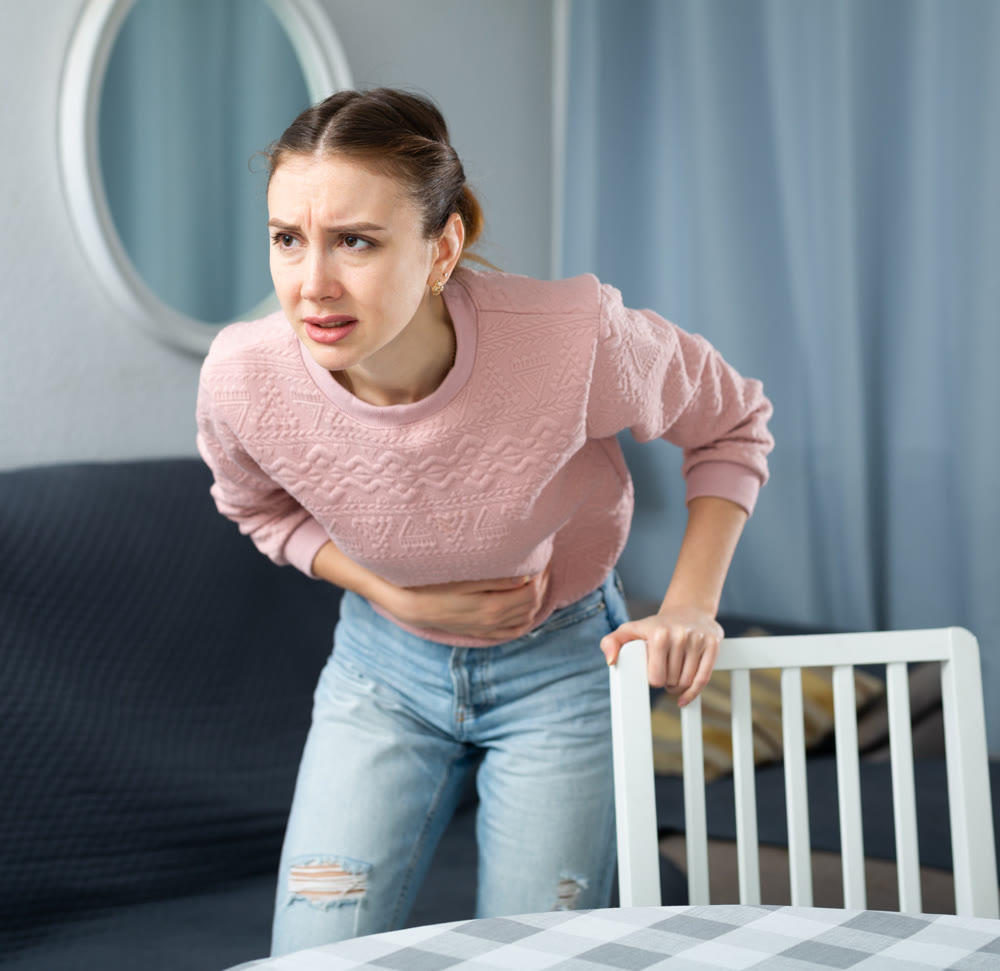 Young woman suffering from abdominal pain