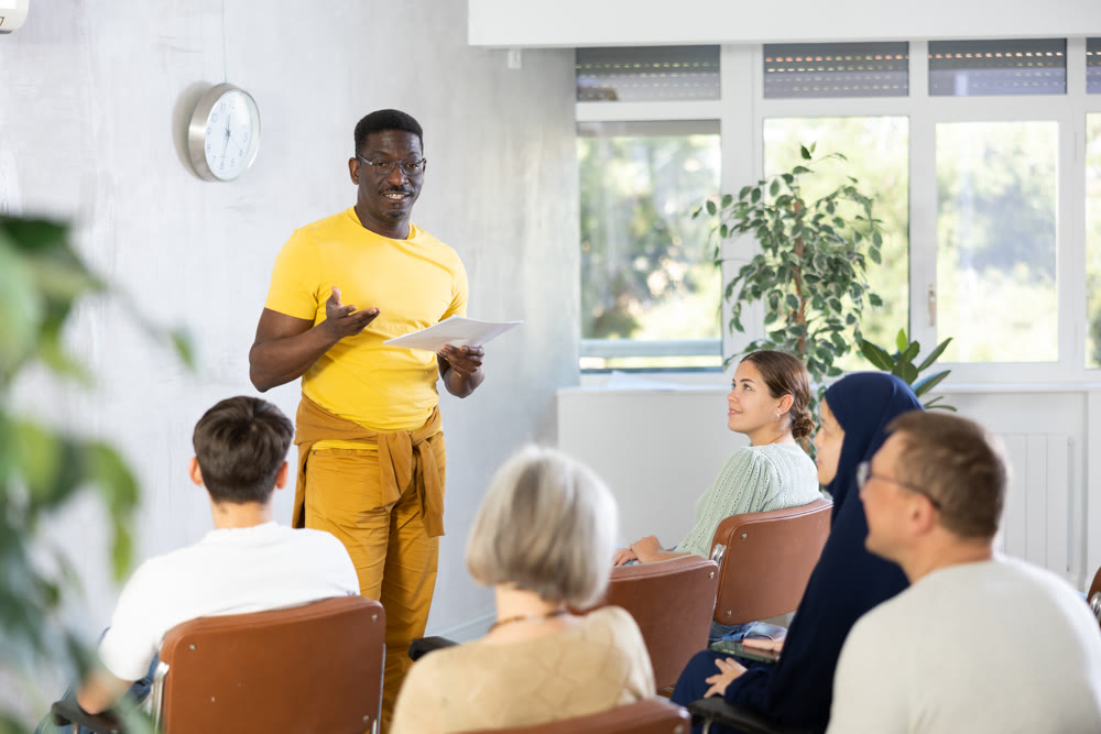 African american tutor giving lecture to group of adult students