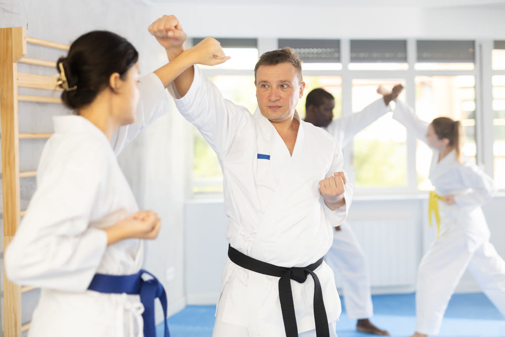 Multinational pupils train to perform defensive karate installations and attacking combat techniques