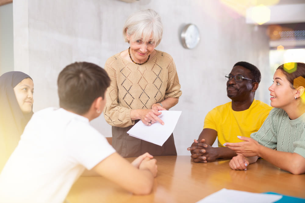Elderly female tutor conducting foreign language speaking club