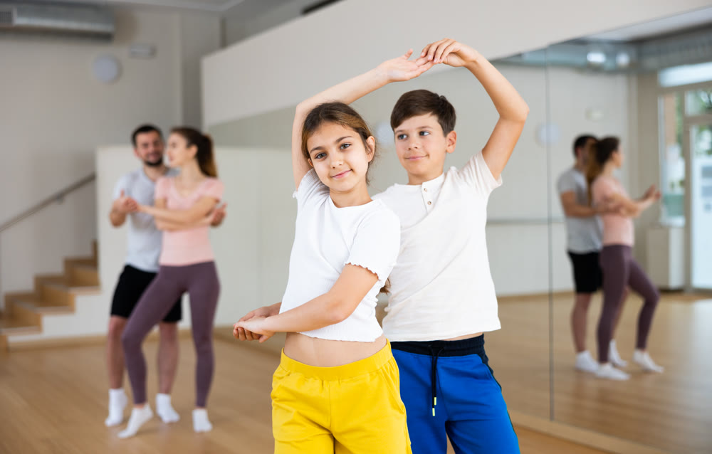 Siblings practicing active dance in pairs