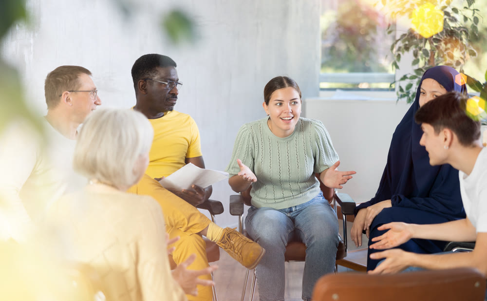 Woman tells an interesting story. Multinational students listening carefully in classroom