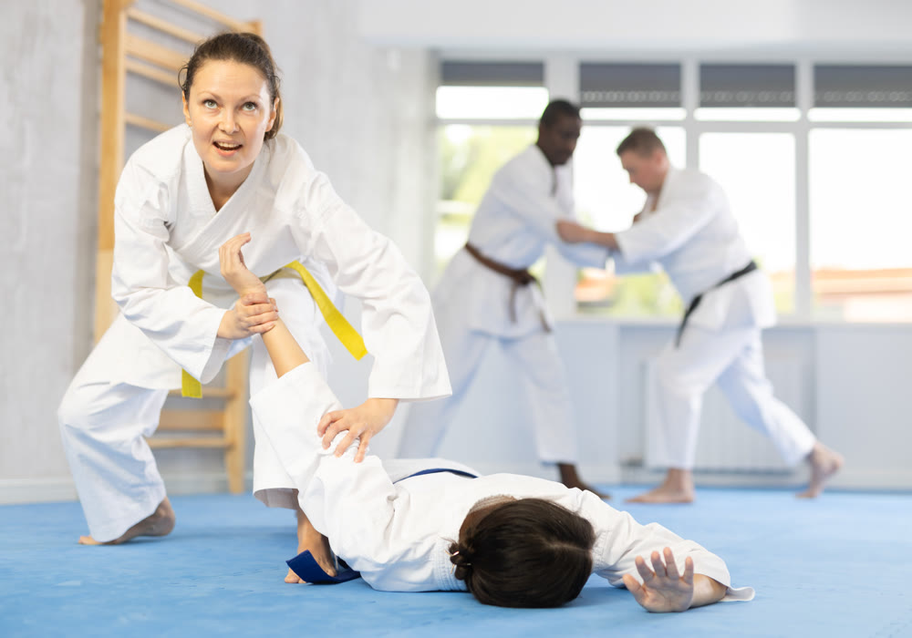 Middle-aged woman twisting her opponent's arm on the floor