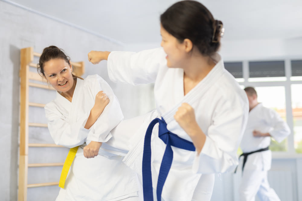 Adult and young women training judo techniques