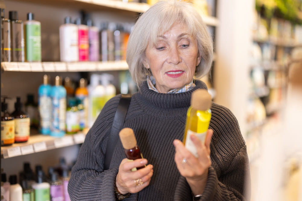 woman chooses cosmetic body oil