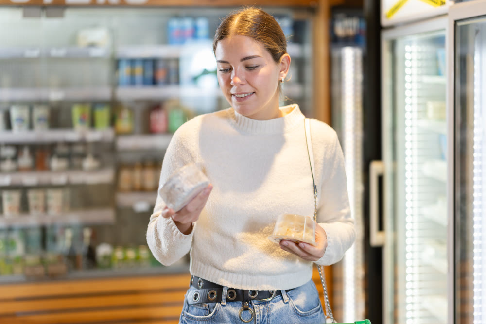 Woman choosing cheese in a store