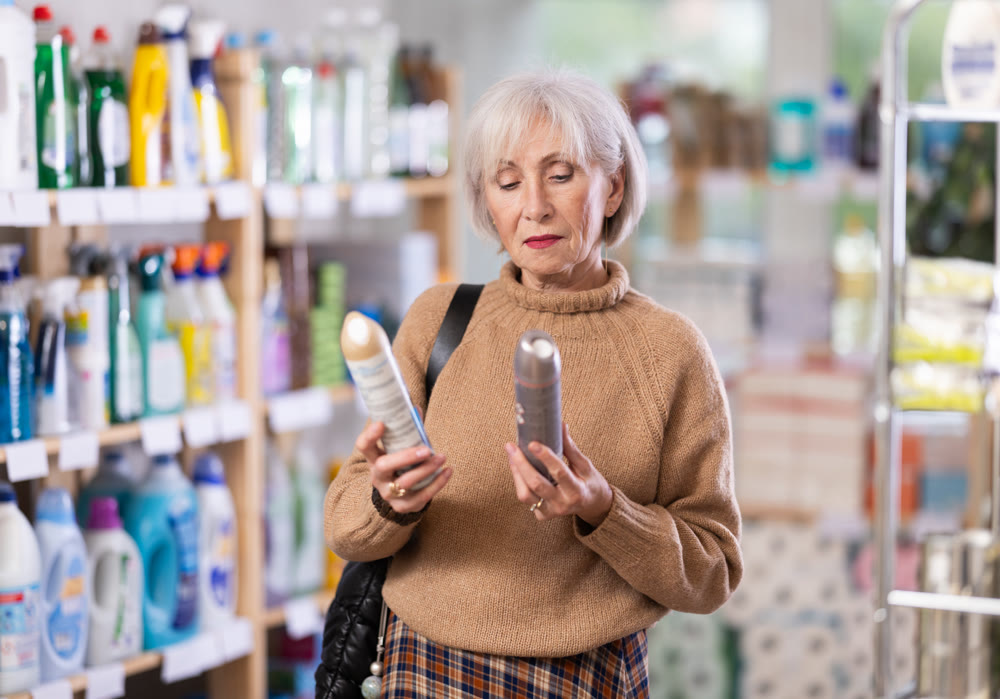 Mature woman choosing hair spray in department store