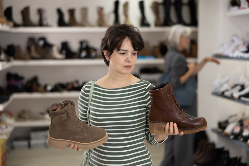 Woman takes samples from showcase and examines shoes