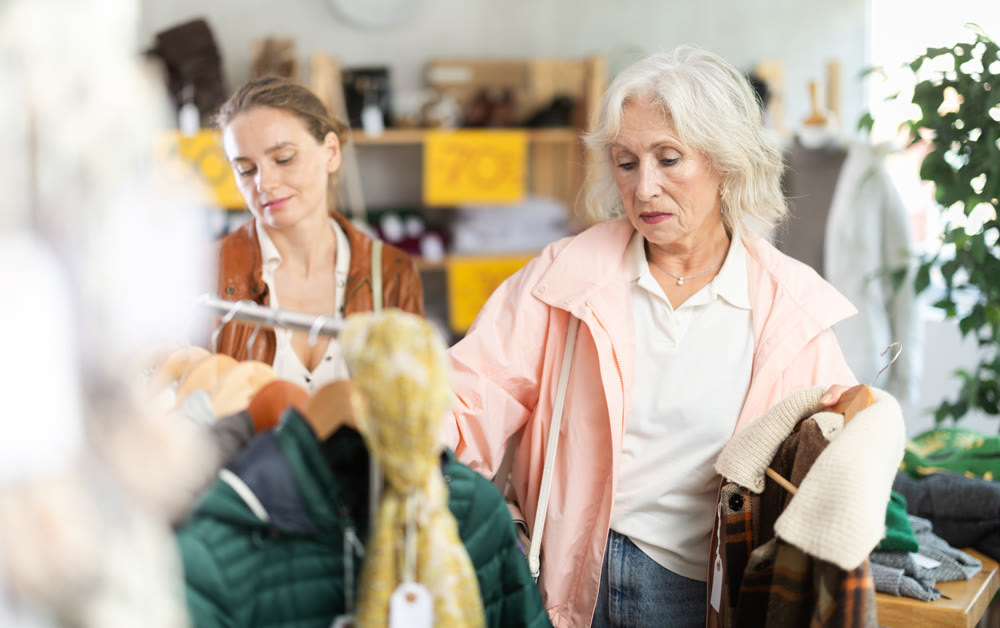woman, together with a mature woman, chooses outerwear
