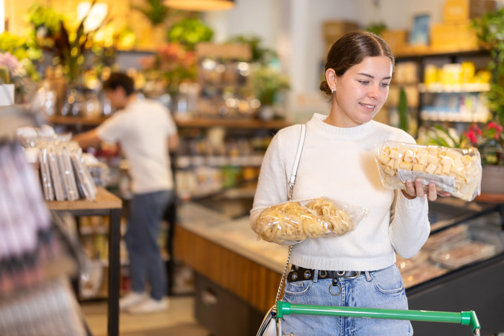 Store visitor, girl in sales area choosing pasta