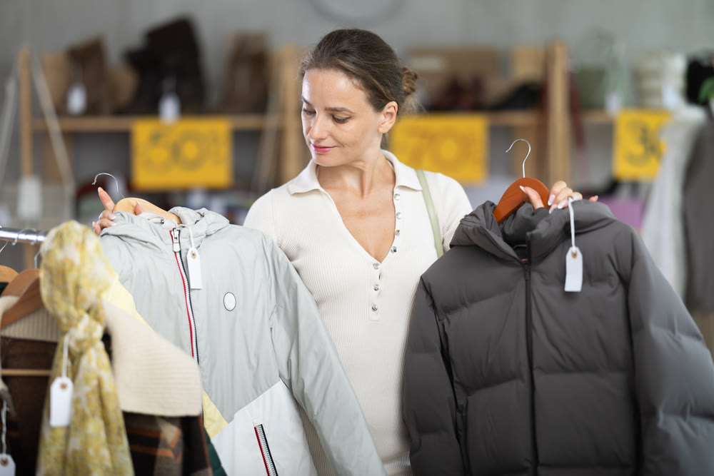 Woman choosing a down jacket in a clothing store