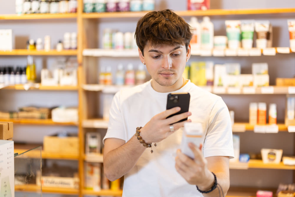 Guy get acquainted with dietary supplement, scan QR code, take reading label using phone camera