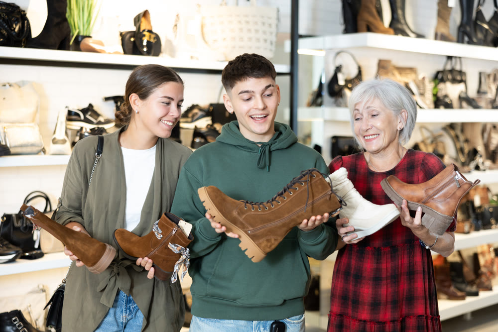 Guy and two women choose boots in store