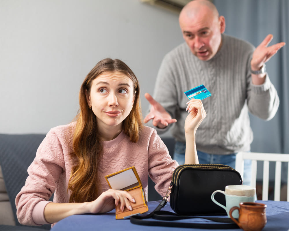 Woman giving back credit card to her husband