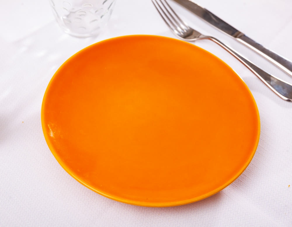 Empty plate and serving pieces on table