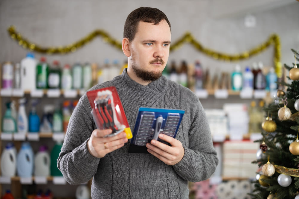 Man choosing razor sets in festively decorated personal care store