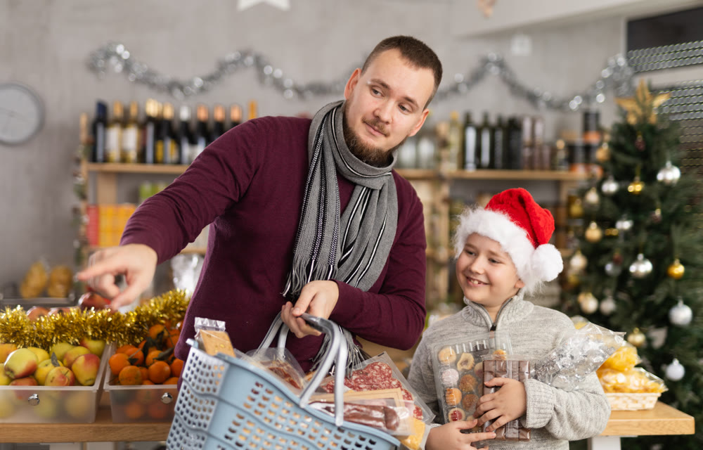 Young man with son choosing products in grocery store