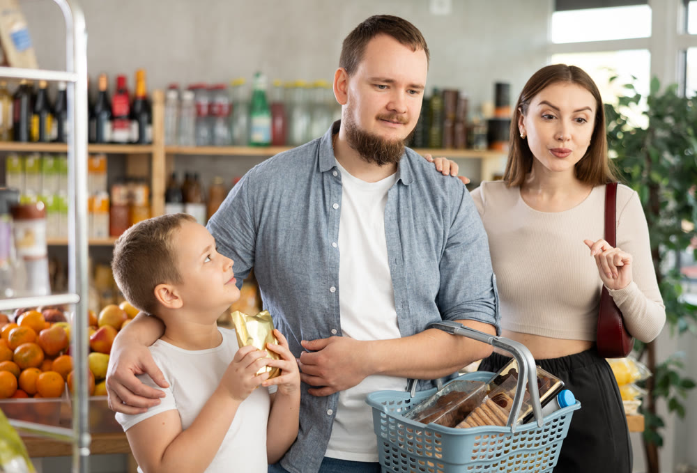 Family shopping - father, mother and son choose and buy products together in supermarket