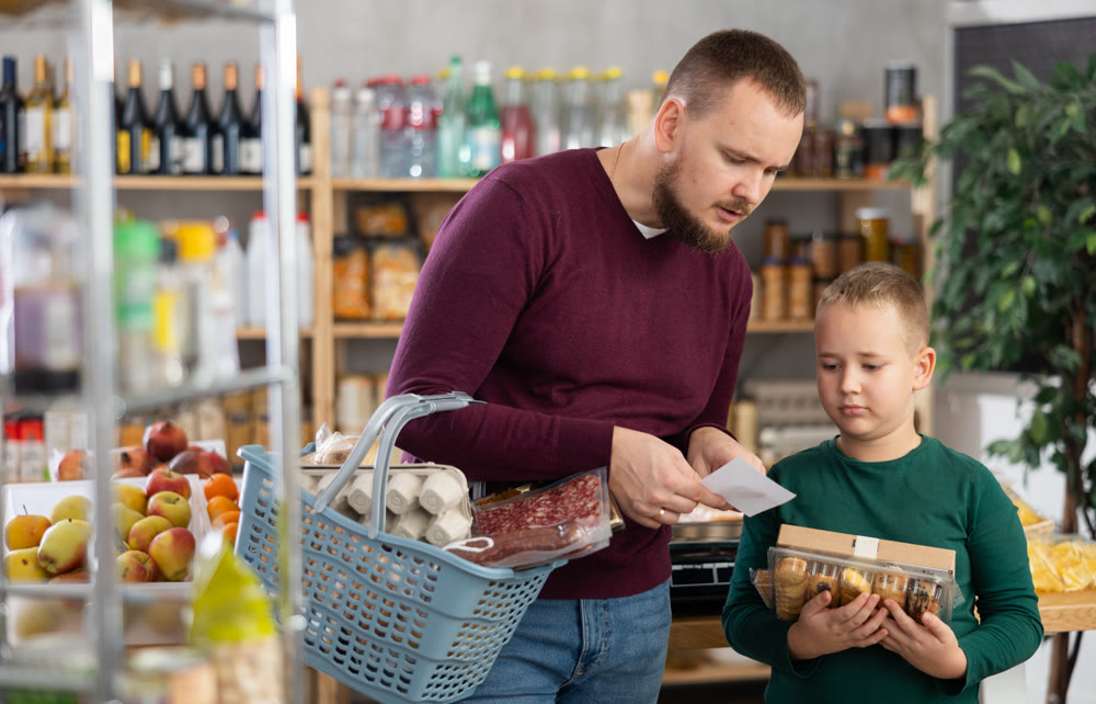 Young man with son buying groceries from shopping list