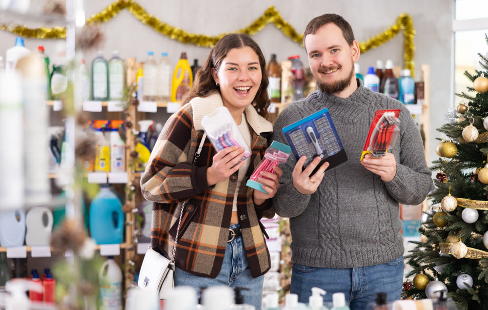 Couple choosing razors in supermarket before celebrating Christmas