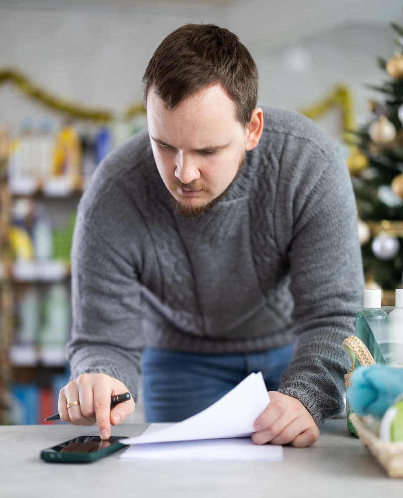 Male businessperson with paper document, plans to replenish restock stores inventory on Christmas Eve