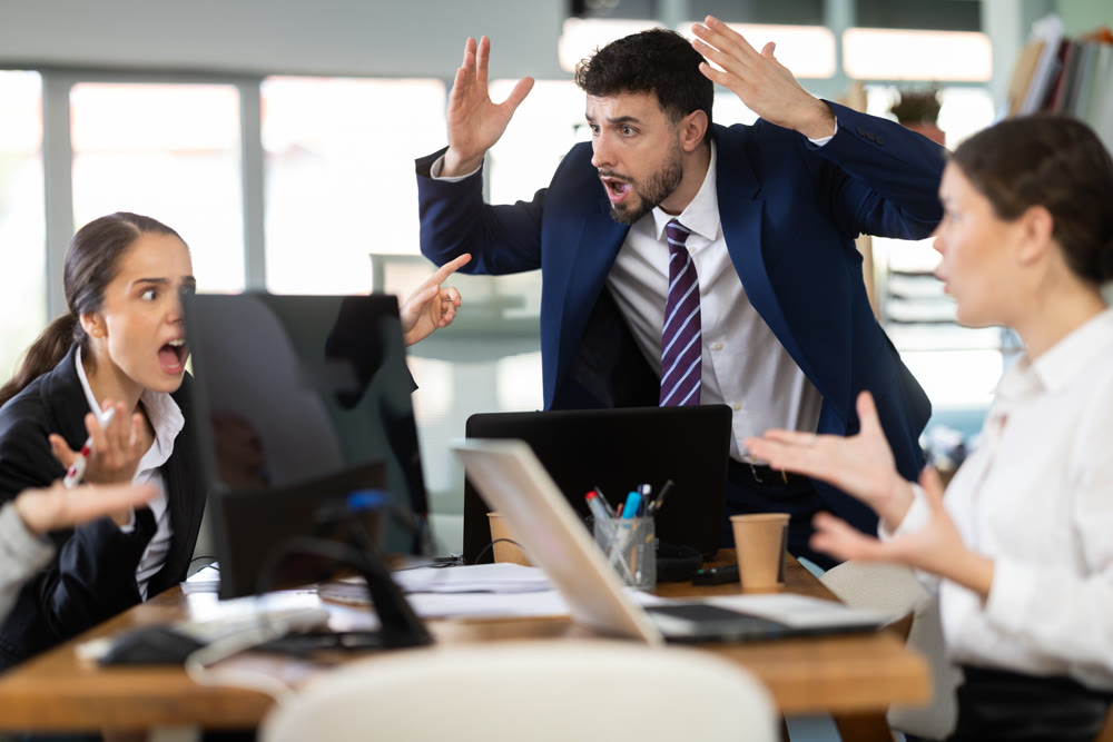 Group of men and women arguing loudly in office