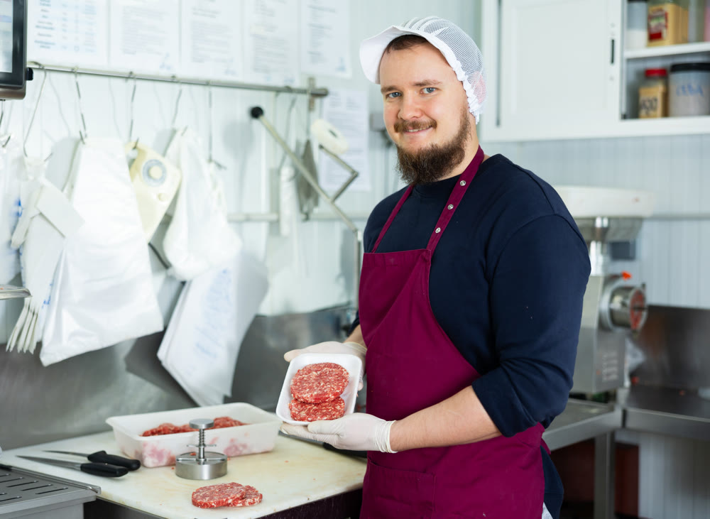 Cooking semi finished products - man shows meat cutlets using special devices